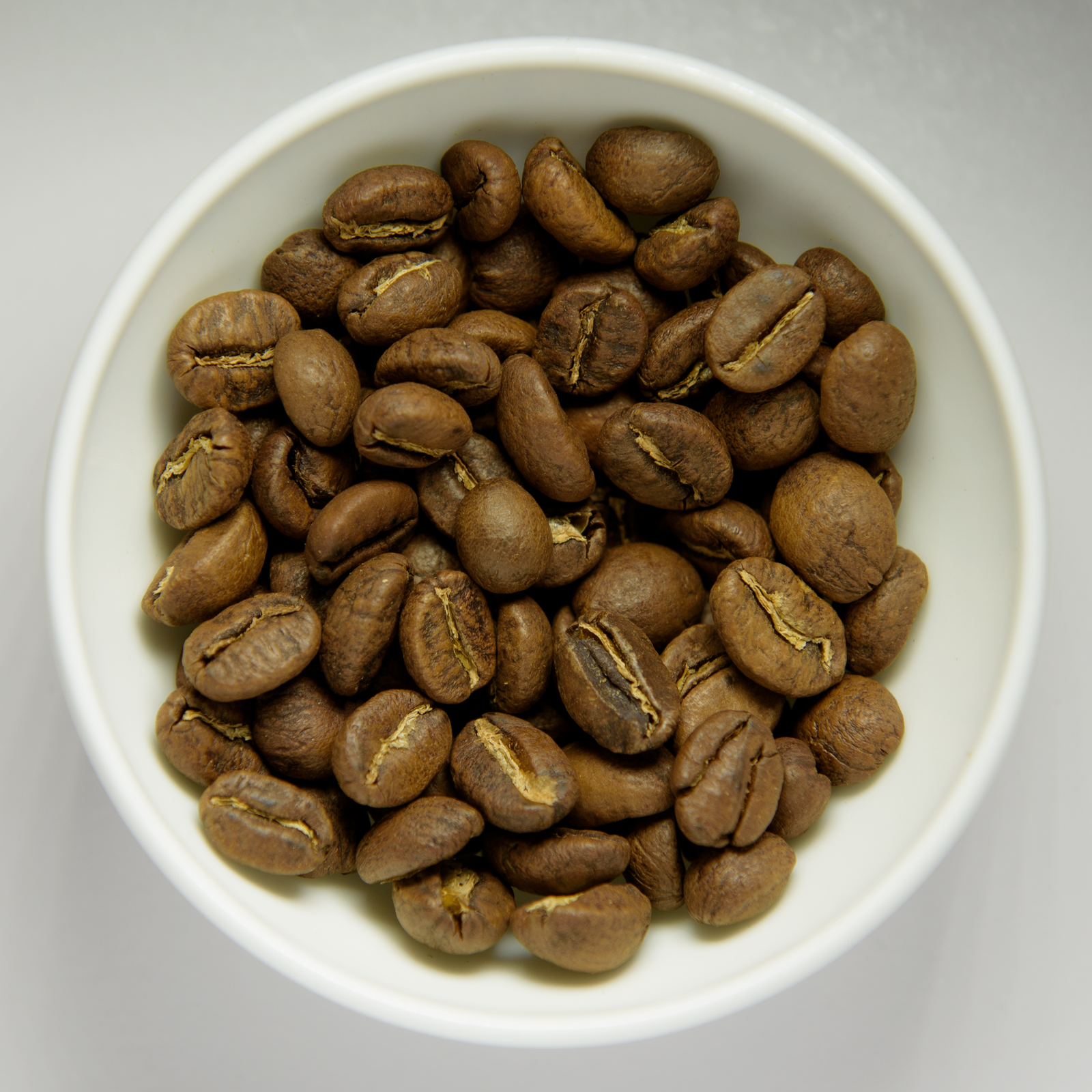 Roasted coffee beans in white bowl (wikimedia: Roasted coffee beans in white bowl.png)